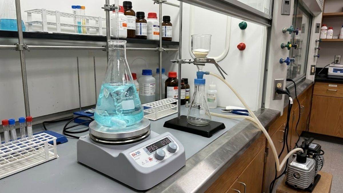 Một góc phòng thí nghiệm với bình nón Supertek đặt trên máy khuấy từ gia nhiệt, bên cạnh là hệ thống lọc chân không